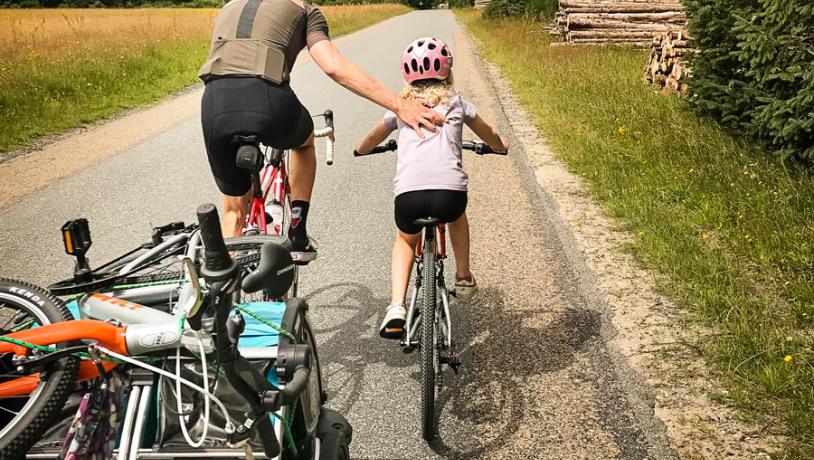 Father helps daughter on a bike trip in the Lake District