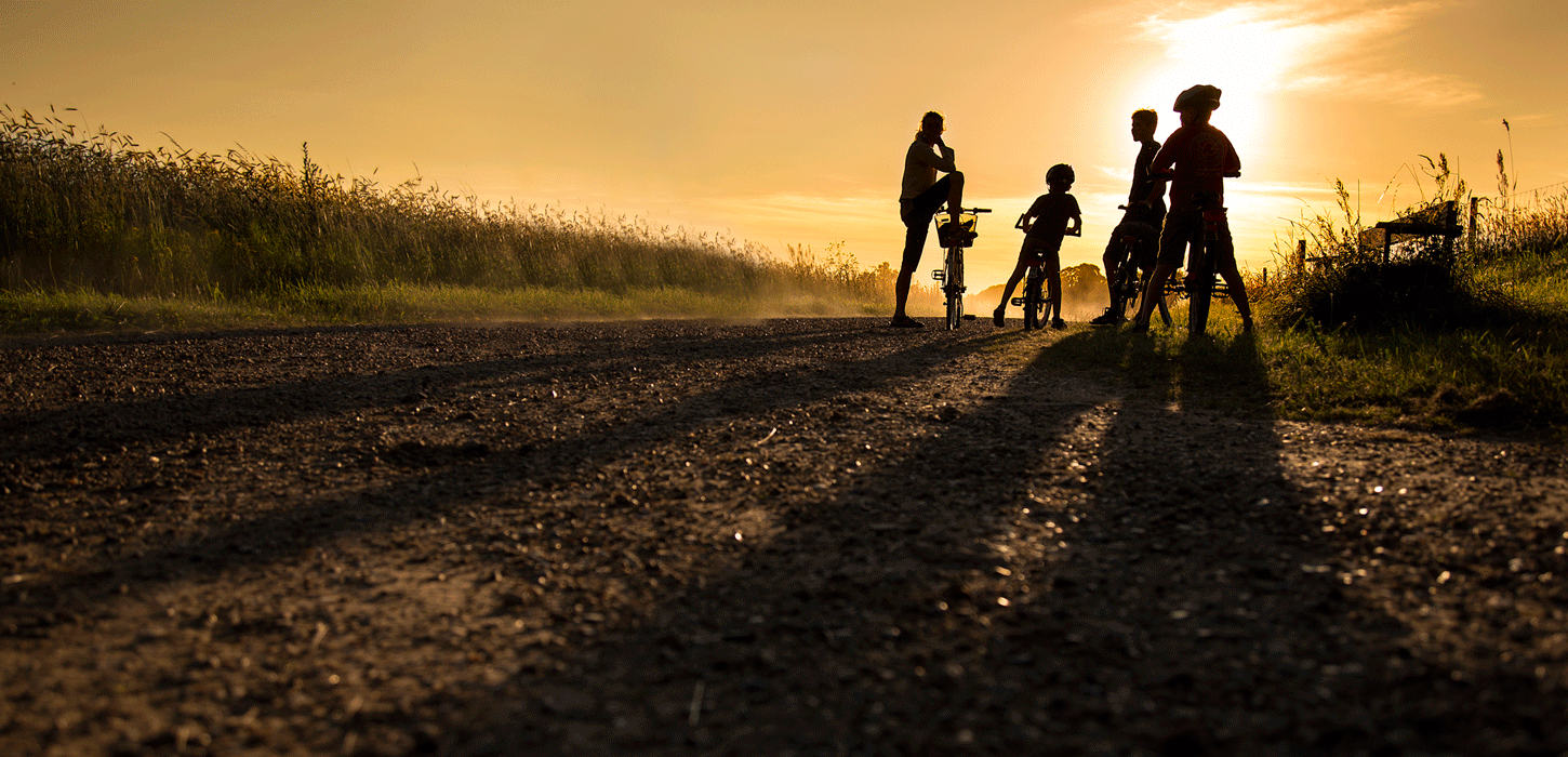 Familie på cykelferie i solnedgang