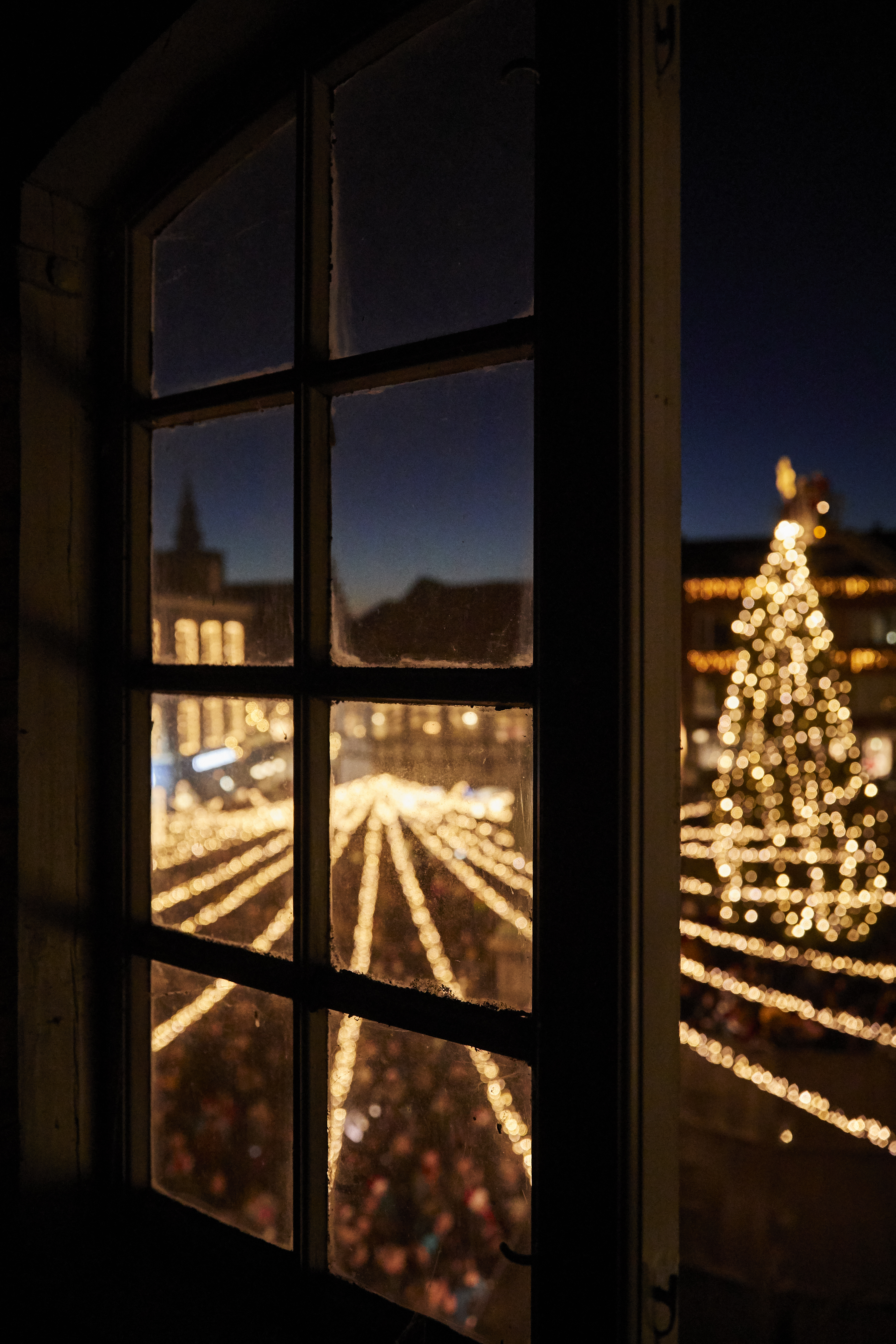 Juletræet ses gennem et vindue i Randers by