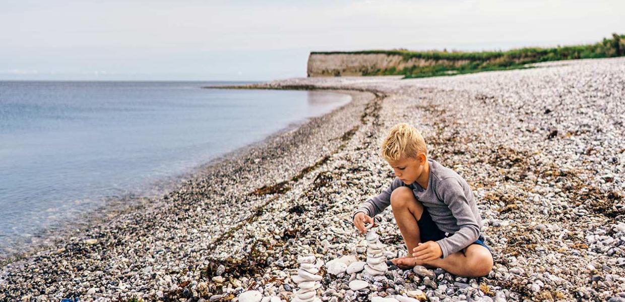 Child playing on the beach by Sangstrup Cliff on Djursland