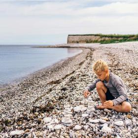 Child playing on the beach by Sangstrup Cliff on Djursland
